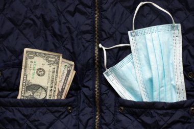 Bir sağlık maskesi ve bir dolar, bir kış ceketinin, paranın ve sağlık hizmetlerinin ceplerinde, karantinadan alınmış bir dohad.