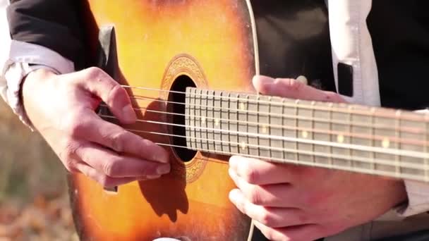 Homem tocando guitarra ao ar livre ao sol close-up, tocando guitarra — Vídeo de Stock