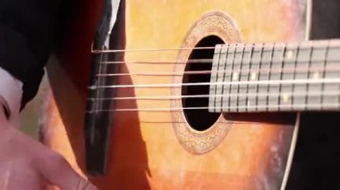 Dışarıda gitar çalan bir adam. Yakın plan, gitar çalıyor.