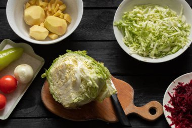 lahana patatesleri biber böceği masada doğruyor, bosch için malzemeler pişiriyor, mutfaktaki masada doğranmış sebzeler, sebzeler