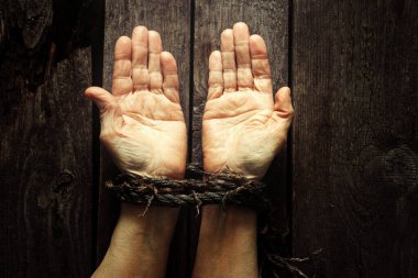 Elleri bağlı yaşlı bir kadının ipiyle ahşap masada