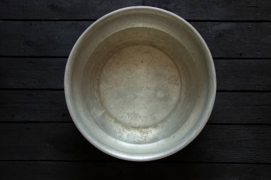 Ayaklarını yıkadıktan sonra sabunlu su dolu bir alüminyum kase sabun ve havlunun yanında, yerde bir kase su, bir kâsede yıkanır.