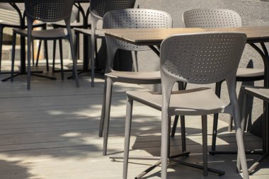 Güneşin altında bir kafede masa ve sandalyeler şehir meydanında bir restoran, restoran mobilyası, sandalye ve bir masa.