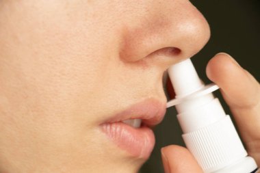 Bir kızın burnu için sprey, burun damlası, gri n ve soğuk algınlığı, nefes alamama, burun tıkanıklığı, ilaç