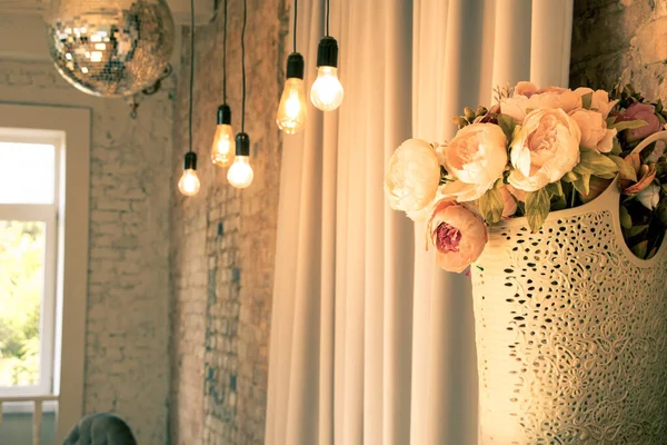 Arka plan için arka plan, dekorasyon için arka plan, arka plan için duvardaki lambaların yanındaki çiçekli buket.
