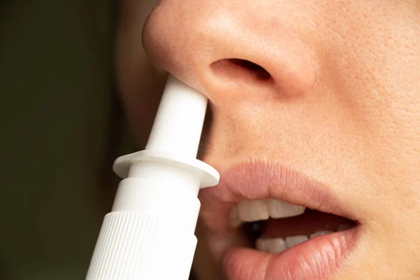 Bir kızın burnu için sprey, burun damlası, gri n ve soğuk algınlığı, nefes alamama, burun tıkanıklığı, ilaç