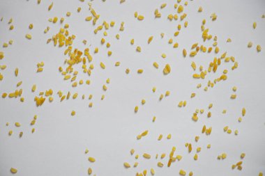 Beyaz bir tabağa serpiştirilmiş bulgur lapası, serpilmiş mısır gevreği.