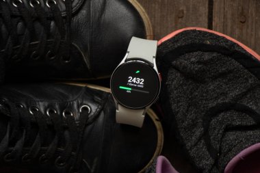 Ukrayna Dnipro 30.11.2021 - Akıllı saat Samsung Galaxy 4.40 mm ve Samsung ve spor ayakkabıları için bir cep telefonu
