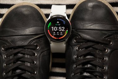 Ukrayna Dnipro 30.11.2021 - Akıllı saat Samsung Galaxy 4.40 mm ve Samsung ve spor ayakkabıları için bir cep telefonu