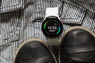 Ukrayna Dnipro 30.11.2021 - Akıllı saat Samsung Galaxy 4.40 mm ve Samsung ve spor ayakkabıları için bir cep telefonu