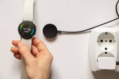 Ukrayna Dnipro 30.11.2021 - Akıllı saat Samsung Galaxy Saat 4.40 mm ve saat, telefon ve manyetik şarj uygulamalı cep telefonu