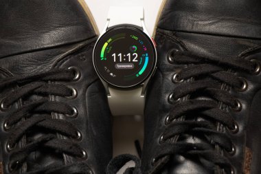 Ukrayna Dnipro 30.11.2021 - Akıllı saat Samsung Galaxy 4.40 mm ve Samsung ve spor ayakkabıları için bir cep telefonu