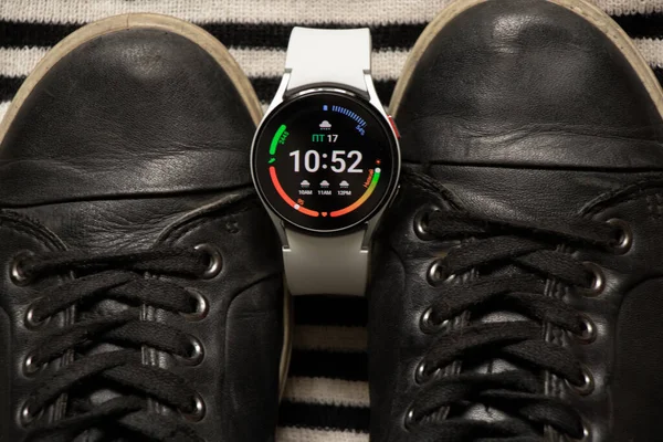 Ukrayna Dnipro 30.11.2021 - Akıllı saat Samsung Galaxy 4.40 mm ve Samsung ve spor ayakkabıları için bir cep telefonu