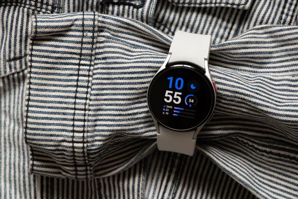 Ukrayna Dnipro 30.11.2021 - Samsung Galaxy 4.40 mm akıllı saat ve Samsung uygulamalı cep telefonu ve kot çizgili gri ceket