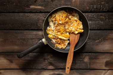 Kızarmış yumurta ve sebzeli tava yemek ve yemek için mutfaktaki masada.