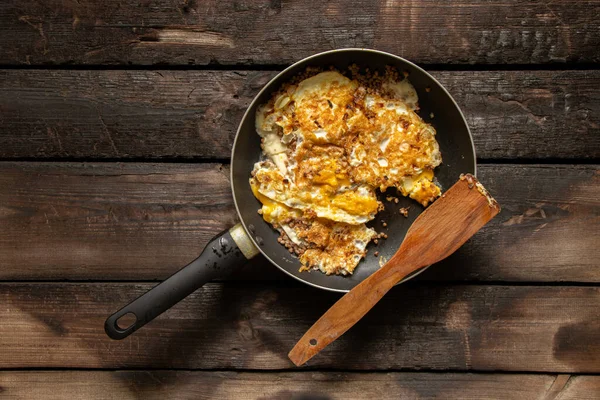 Kızarmış yumurta ve sebzeli tava yemek ve yemek için mutfaktaki masada.