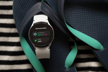 Ukrayna Dnipro 30.11.2021 - Akıllı saat Samsung Galaxy 4.40 mm Denizde plaj ayakkabılarının yanında dinlenme