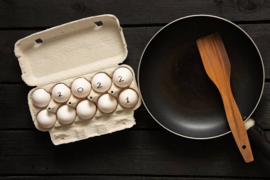 Kutularda tavuk yumurtası ve yumurtalar 2022, mutlu yıllar 2022, masada tavuk yumurtası ve kızartma tavası, çırpılmış yumurta