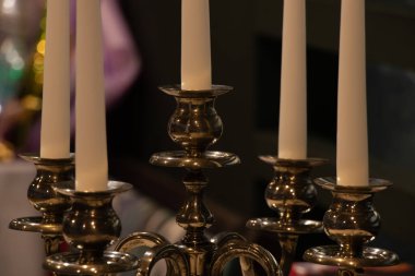 Dekoratif şamdan, karanlıkta bir masada üç mum, şamdanda bir mum.