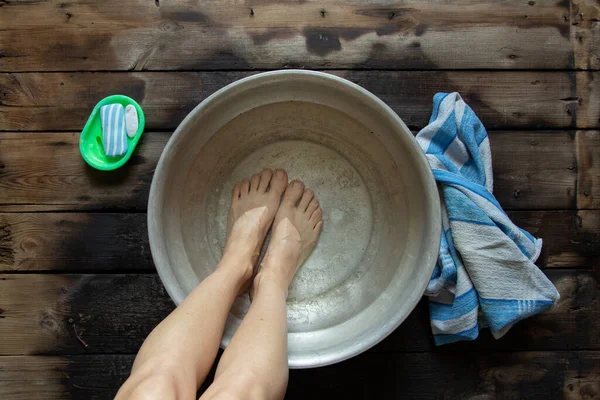 Flicka Tvättar Fötterna Ett Handfat Med Vatten Trägolvet Hemma Fotvård — Stockfoto