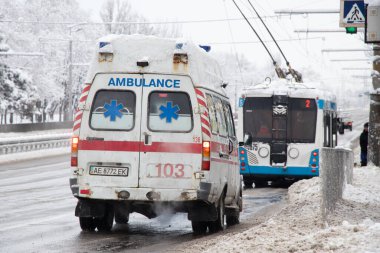 Ukrayna Dnipro 27.12.2021 - Ambulans kışın karda yolda, eski paslı ambulans şehrin merkezinde kışın karda yolda