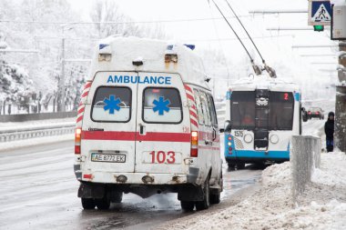 Ukrayna Dnipro 27.12.2021 - Ambulans kışın karda yolda, eski paslı ambulans şehrin merkezinde kışın karda yolda