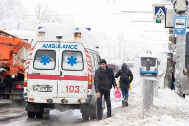 Ukrayna Dnipro 27.12.2021 - Ambulans kışın karda yolda, eski paslı ambulans şehrin merkezinde kışın karda yolda