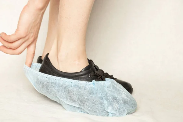 Vrouwelijke Benen Zwarte Schoenen Blauwe Wegwerp Laarzen Een Witte Achtergrond — Stockfoto