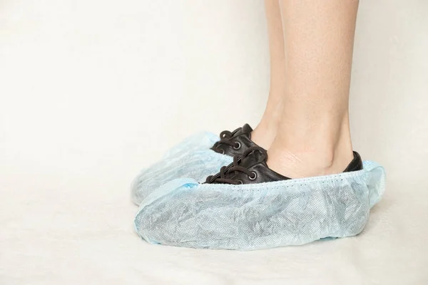 Női Lábak Fekete Cipőben Kék Eldobható Csizma Fehér Alapon Védő — Stock Fotó