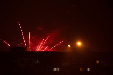 Gece gökyüzünde havai fişekler Ukrayna 'nın bir uyuma alanındaki çok katlı binaların arka planına karşı, Dnipro şehrinde, mutlu yıllar 2022