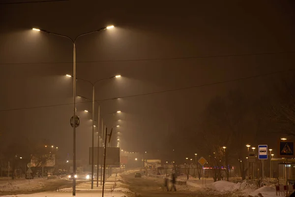 road in a residential area of the city of Dnipro in Ukraine at night in winter for the new year, lights of the night city in winter