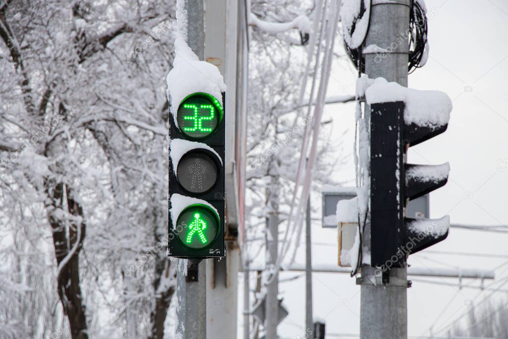 a green traffic light in winter in snow and ice in Ukraine in the city of Dnipro, roads were lifted, a traffic light in the city