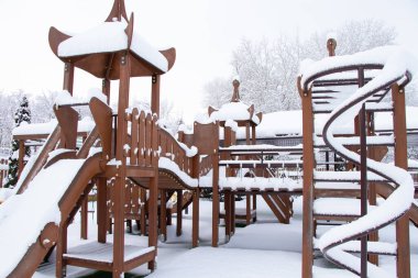 Çocuklar kışın Ukrayna 'da bir parkta salıncakta sallanıyor. Dnipro şehrinde, kışın şehirde.