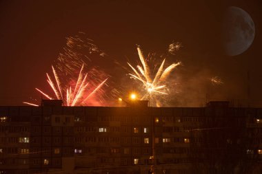 Gece gökyüzünde havai fişekler Ukrayna 'nın bir uyuma alanındaki çok katlı binaların arka planına karşı, Dnipro şehrinde, mutlu yıllar 2022