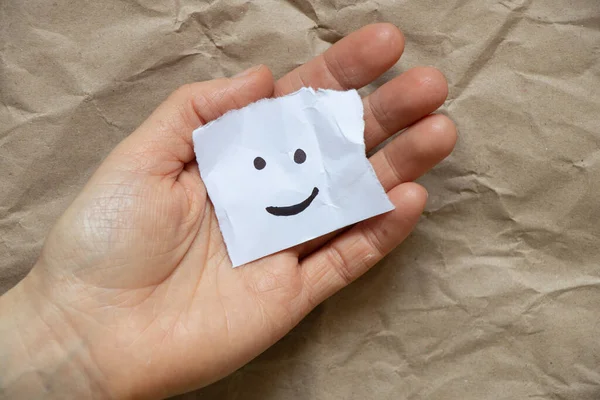 Ein Fröhliches Emoticon Wird Auf Ein Blatt Papier Den Händen — Stockfoto
