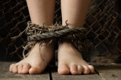 dětské nohy svázané starým špinavým provazem, otroctví a krádeží lidí, dětinské otroctví