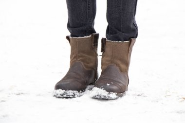 Kadın bacakları kışın botlarla şehirde sokakta, kadın botları karda.