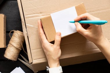 Kadın çevrimiçi mağazası, küçük işletme sahibi, girişimci, paketleme çantası, posta kutusu hazırlama paketi. E-ticarette sevkiyat konsepti düştü. Ürün ambalajı.