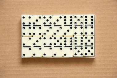 Kahverengi kağıt üzerinde domino taşları. Yakın plan, domino etkisi.