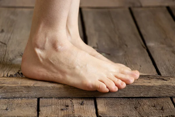 a girl with bare feet walks on an old wooden floor at home, bare feet