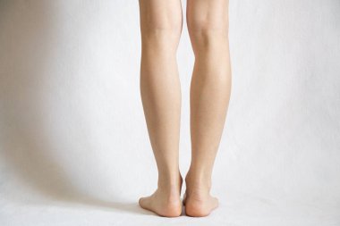 Beyaz arka planda çıplak kadın bacakları, yakın plan, beyaz ayaklar