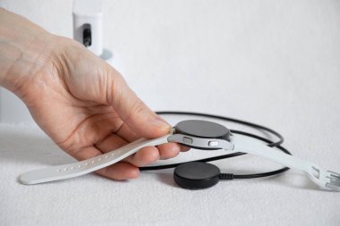 Ukrayna Dnepr 14.02.2021 - Akıllı saatler Samsung Galaksi İzleme. 4.40 mm ve prizde kablosuz şarj, saat beyaz bir arkaplan üzerine şarj