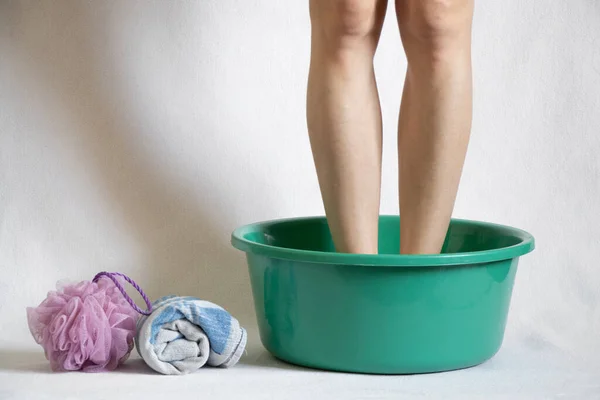 Ένα Κορίτσι Πλένει Πόδια Της Ένα Πράσινο Μπολ Λευκό Φόντο — Φωτογραφία Αρχείου