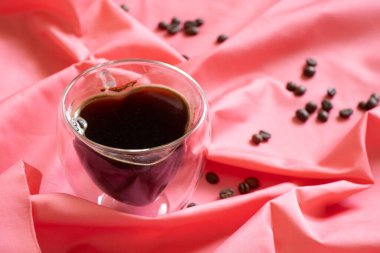 Masa örtüsü üzerinde kalp şeklinde bir fincan kahve, sabah kahvesi ve romantizmi.