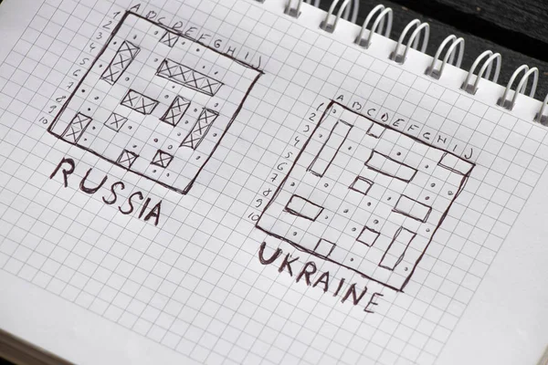 drawing of a children\'s game sea battle with the text Russia and Ukraine in a notebook, the field of Russian ships is broken, Russia\'s failure in the war with Ukraine, no war