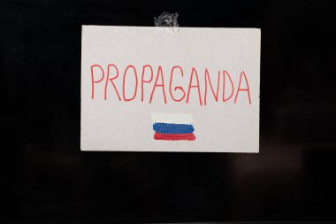 Propaganda ve Rusya bayrağı, televizyonda asılı duran bir tabakta yazıyor. Rus propagandasına dikkat edin, Ukrayna 'daki savaşı durdurun.