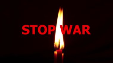 Siyah arka planda yanan bir mum ve kırmızı yazılar savaşı durduruyor, Ukrayna 'da barış, savaş yok, Ukrayna için dua