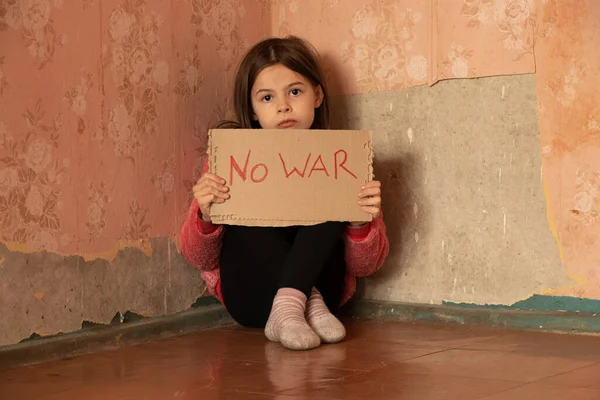 Küçük bir kız Ukrayna 'daki evinde savaşı durduracak bir poster tutuyor ve Ukrayna' daki savaşı durdurmak istiyor, çocuklar bir protesto eylemi istiyorlar.
