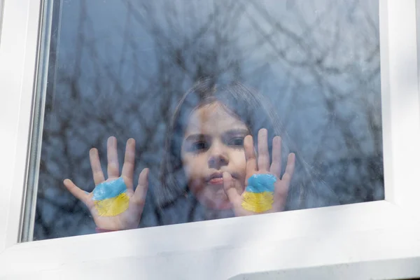 Маленькая Девочка Окне Своего Дома Раскрашенным Желто Голубым Флагом Украины — стоковое фото