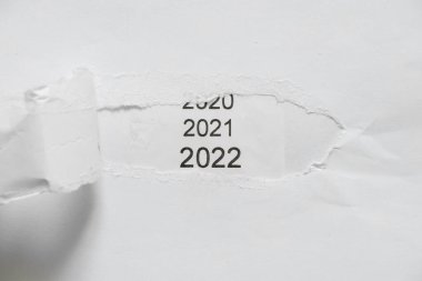 2021 ve 2022 yazıtları kağıttaki bir delikten görünür, arka plan olarak 2022.